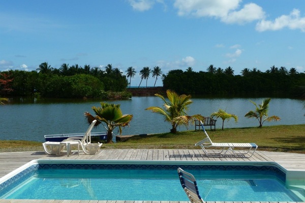 Una piscina al aire libre, sillones reclinables de piscina