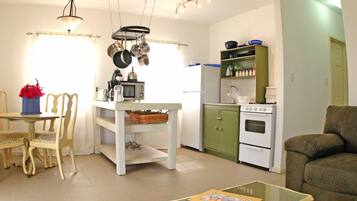 A compact living space with a dining area, kitchenette, and seating area.