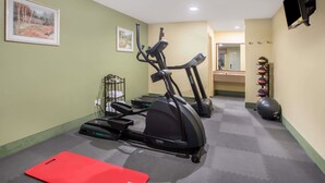 A gym with treadmills, a stationary bike, and a red mat. - Days Inn by Wyndham Abbeville (Abbeville)