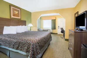 A hotel room with a large bed, a desk with a chair, a television, and a wardrobe. - Days Inn by Wyndham Abbeville (Abbeville)