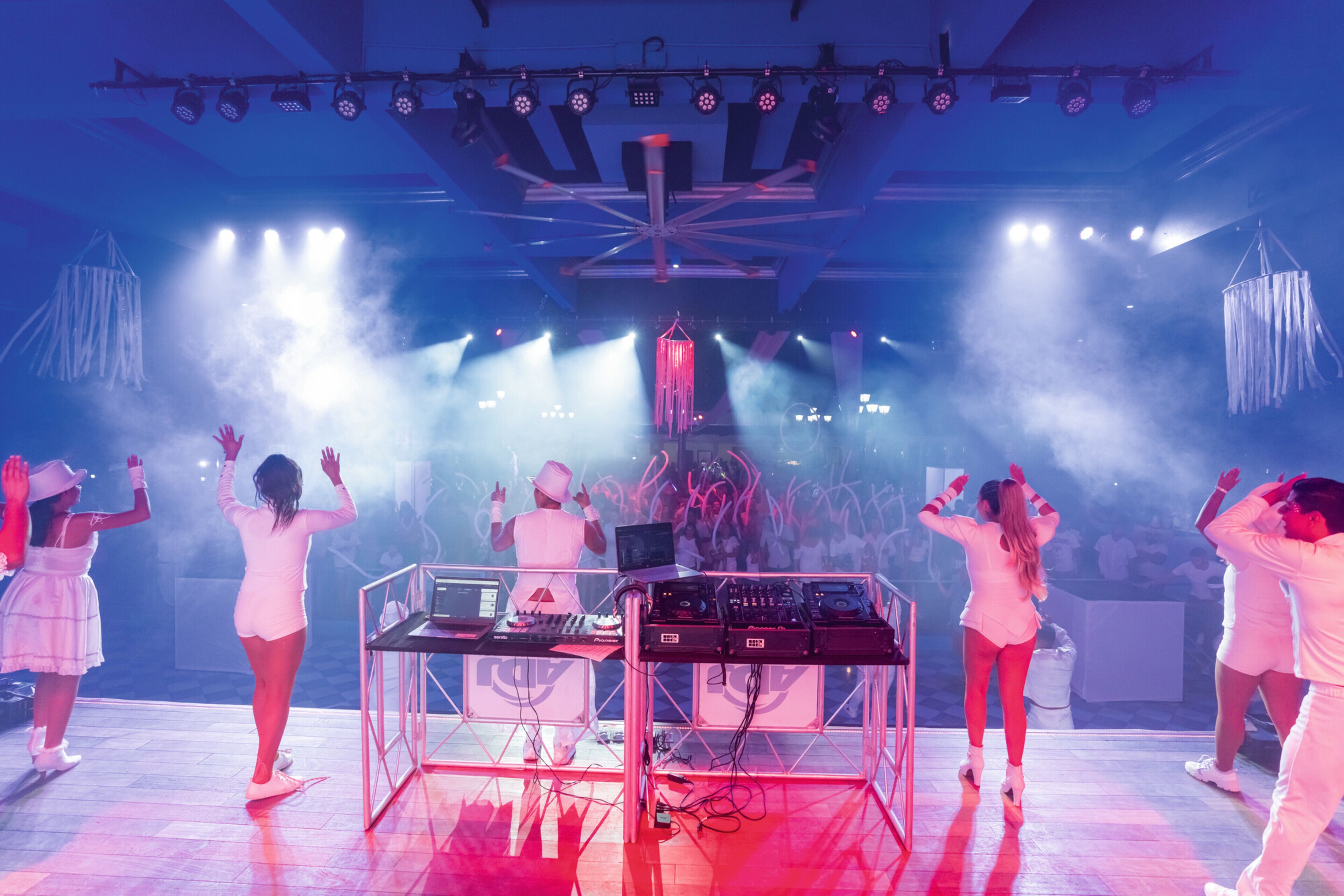 A stage with performers and a DJ setup.