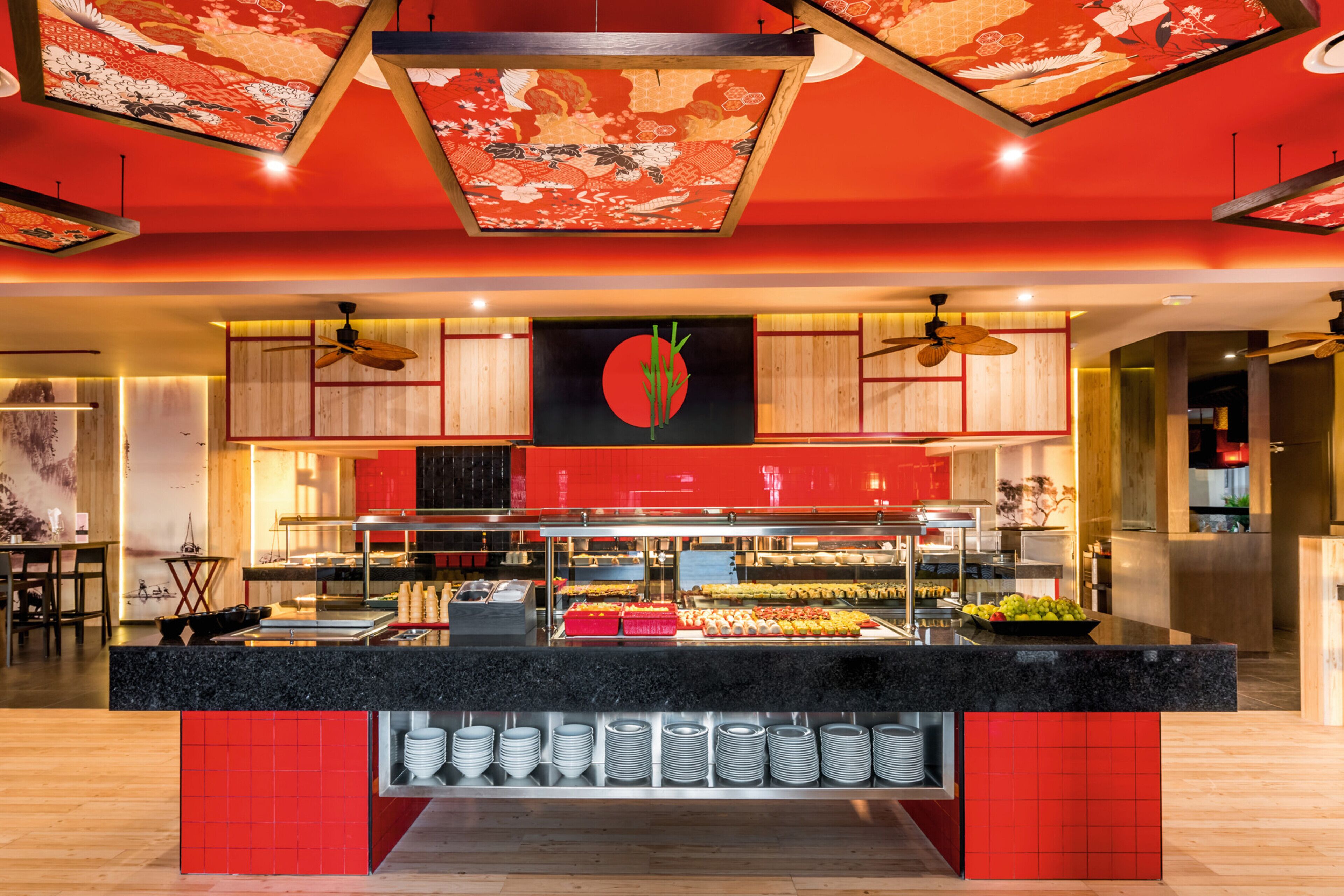 A buffet area with a central island, surrounded by wooden cabinets and a red-tiled floor.