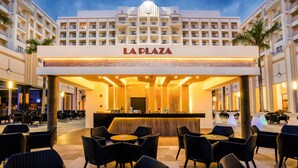 A hotel lobby with a bar area, seating, and a large sign reading "LA PLAZA". - Hotel Riu Vallarta - All Inclusive (Nuevo Nayarit)