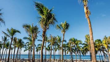 Di pantai, kursi berjemur, handuk pantai, dan pijat di pantai