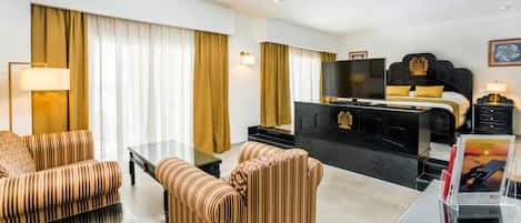 A hotel room with a bed, a TV, a desk, and a sofa.