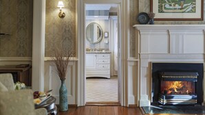 A room with a fireplace, a mirror, and a framed picture on the wall. - Arrowhead Inn (Durham)