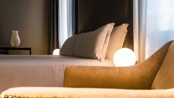 A hotel room with a bed, a nightstand, and a vase.