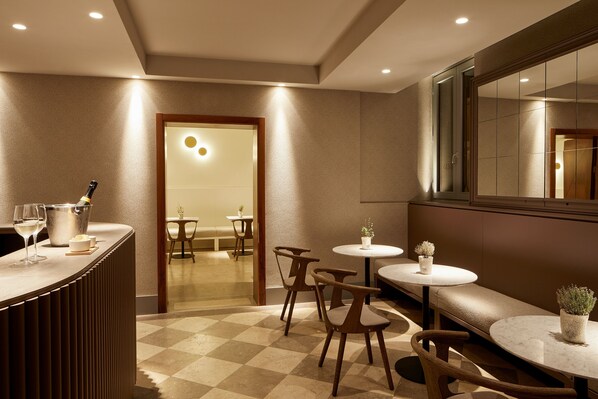 A modern interior with a bar area, seating, and a large mirror.