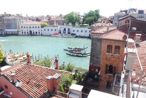 A canal with gondolas, historic buildings, and a bridge.