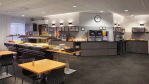 A modern cafe with a counter, seating area, and a clock on the wall. - Hotel Cabin (Reykjavik)