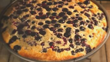 Una fuente redonda con una tarta de arándanos sobre una rejilla enfriadora.