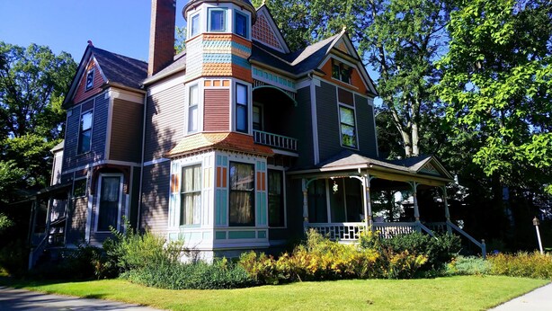 A Victorian-style house with a prominent turret, large windows, and a porch.