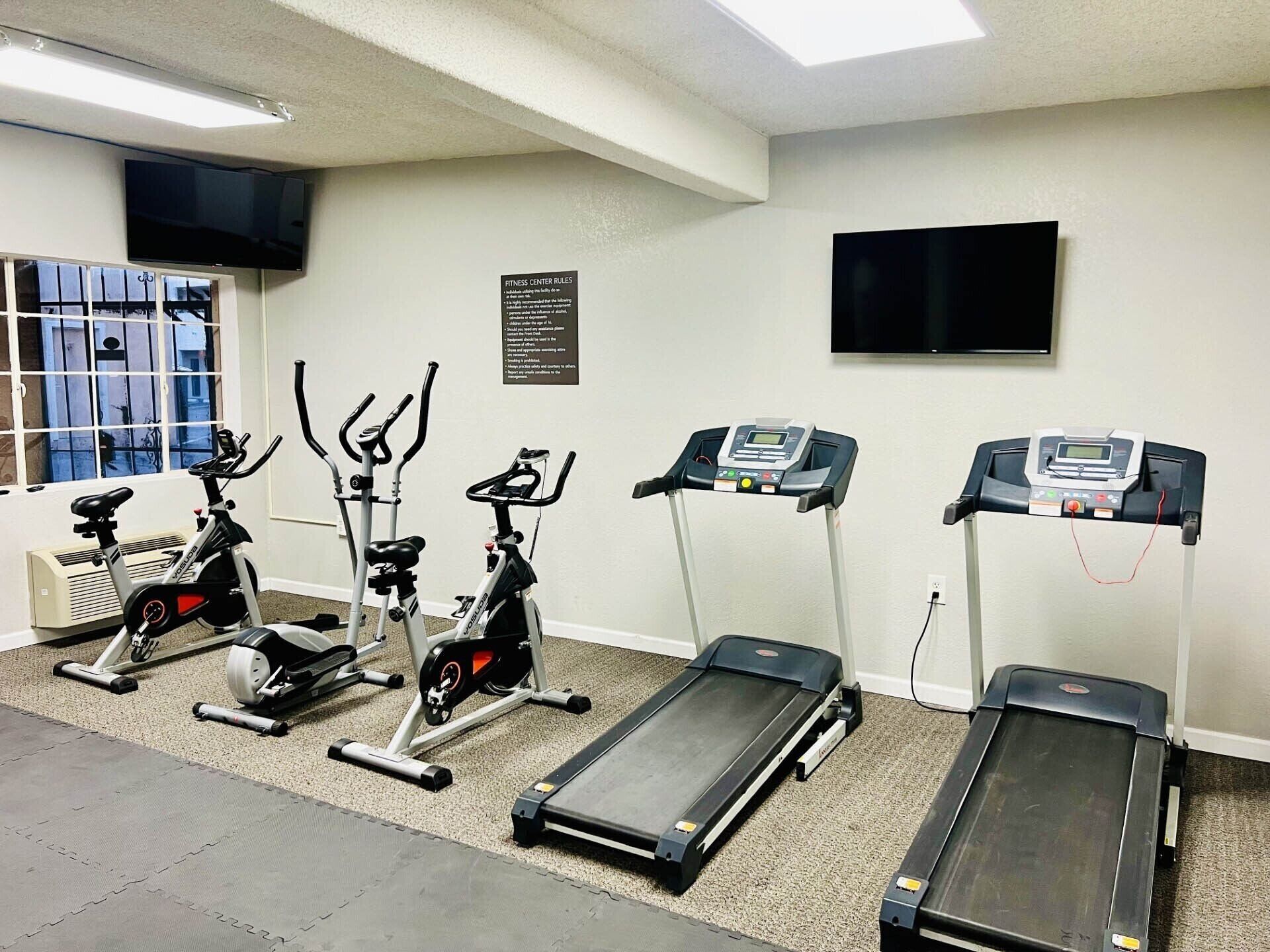 A fitness center with stationary bikes, elliptical machines, and treadmills.