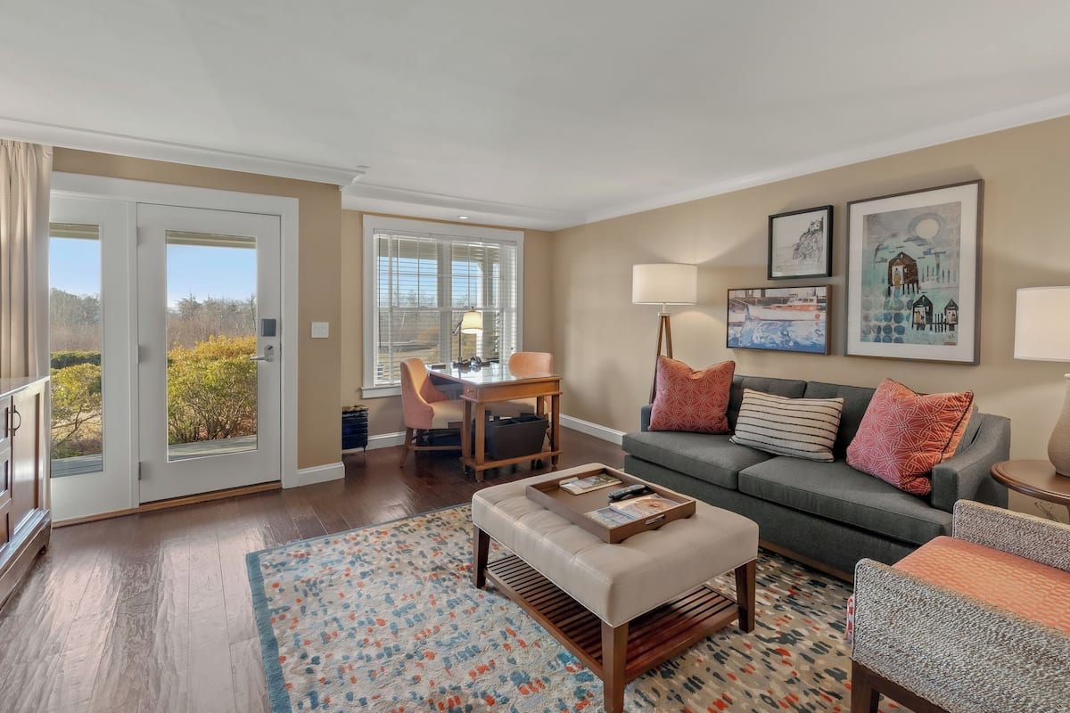 A living room with a sofa, armchairs, a coffee table, and a dining area with a table and chairs.