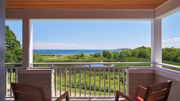 Relax in a serene outdoor space with a scenic view of the water and lush greenery.