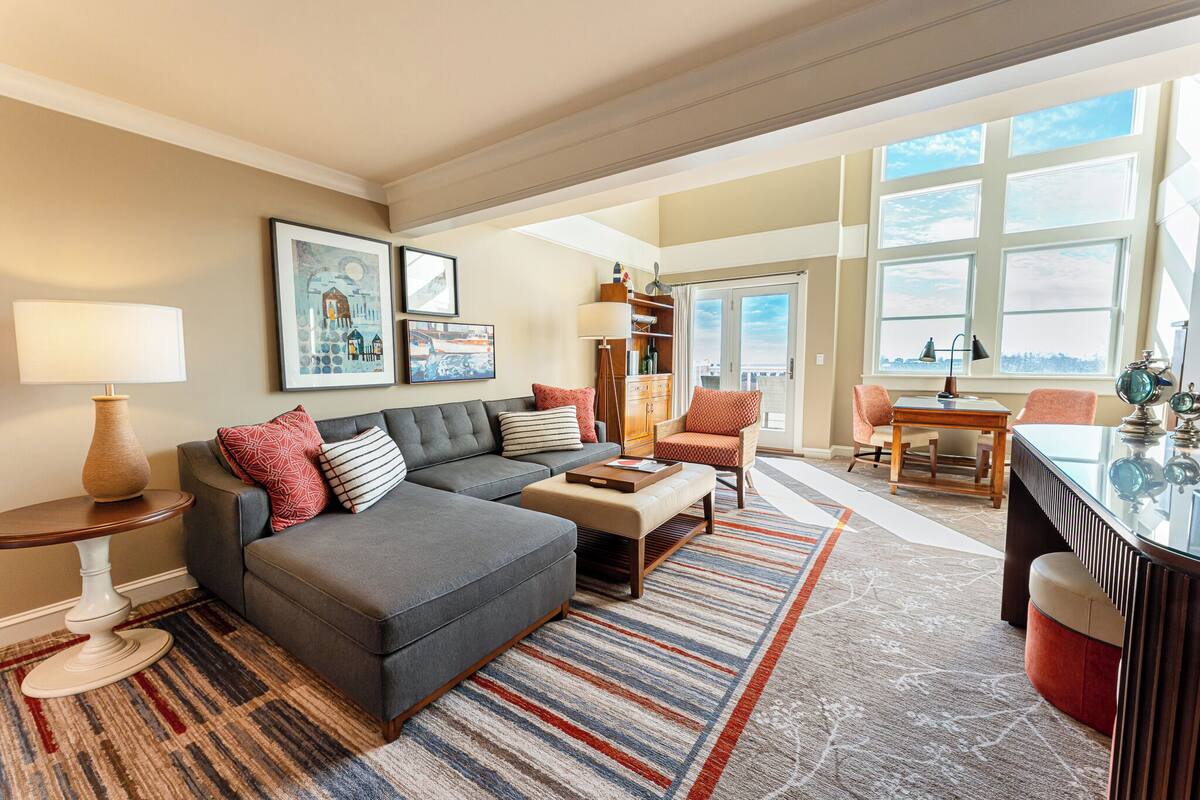 A spacious living room with a sectional sofa, a coffee table, and a dining area with a table and chairs.
