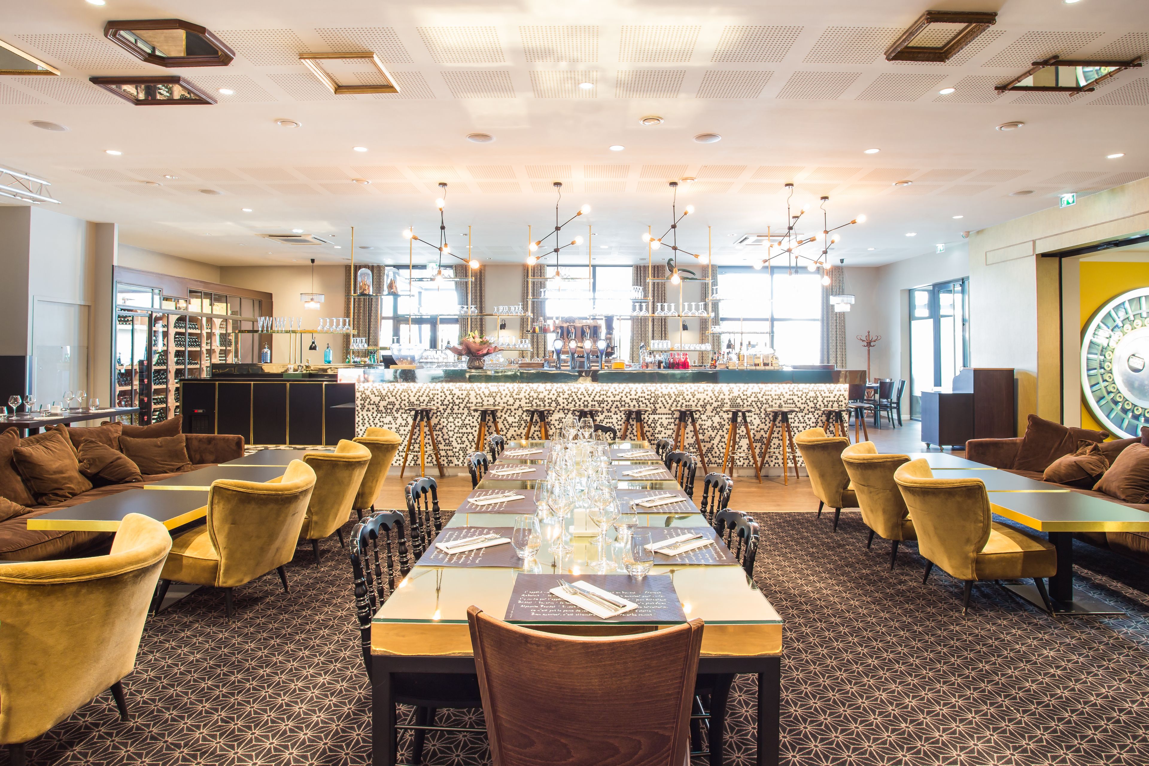 A spacious dining area with a long table set for a meal, surrounded by comfortable seating.