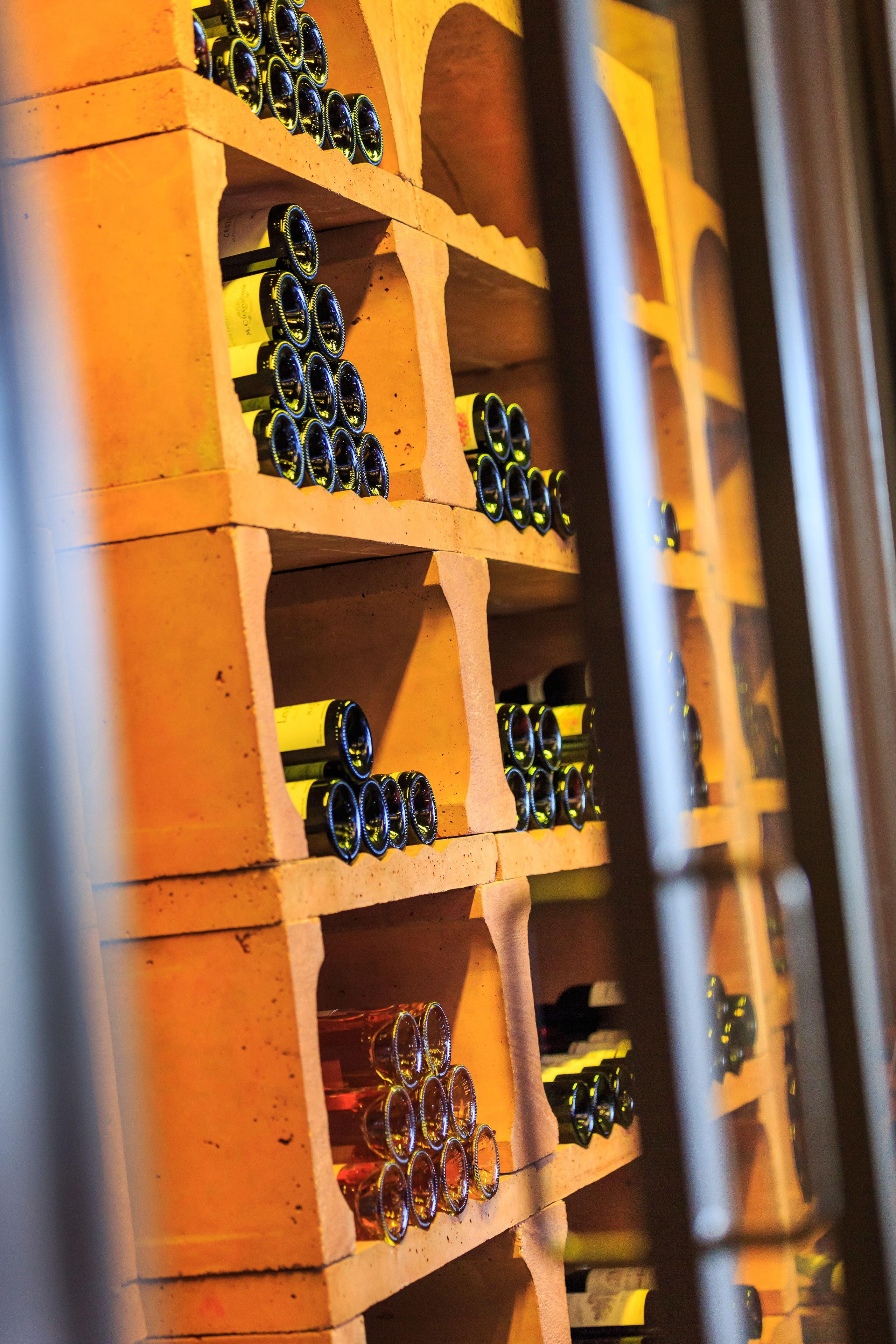 Una dispensa per vino con diversi ripiani pieni di bottiglie.