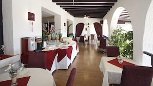 A restaurant with white walls, red tablecloths, and wooden beams on the ceiling. Tables are set with white tablecloths and red runners. - Bel Azur (Six-Fours-les-Plages)