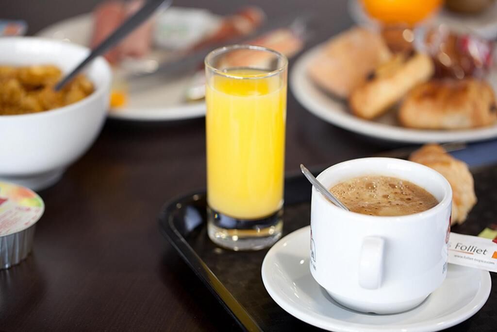 A breakfast tray with a cup of coffee, a glass of orange juice, and a bowl of cereal.