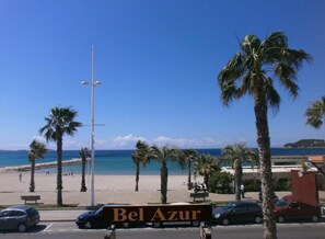 A beach view with a sign for 'Bel Azur' hotel.