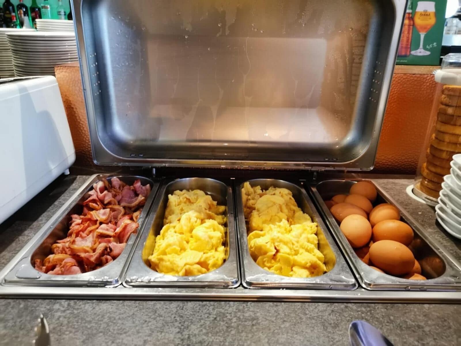 Un buffet proposant des œufs brouillés, du bacon et des œufs.
