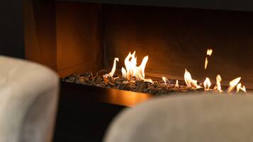 Una chimenea moderna con un diseño limpio y minimalista, que presenta un alero negro y una vista despejada de las llamas.