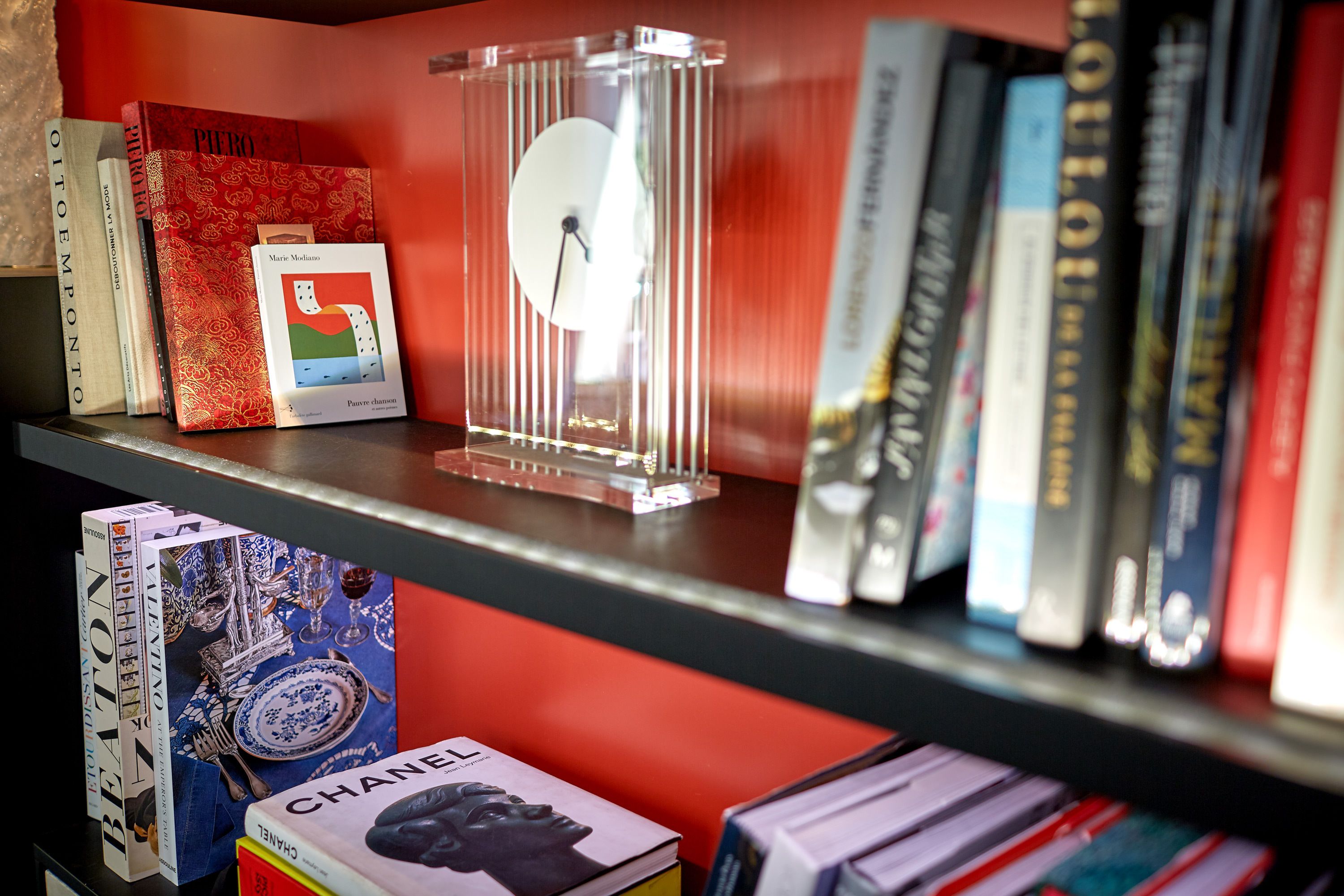 A bookshelf with books and a clock.