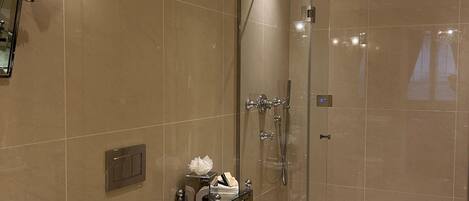 Een moderne badkamer met toilet, wastafel en douche.
