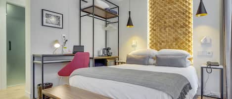 Una habitación de hotel moderna con cama, escritorio, silla y una mesita.