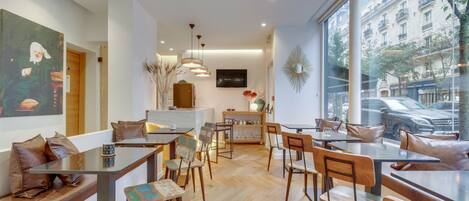 A modern cafe with wooden furniture, a large window with a city view, and a minimalist decor.