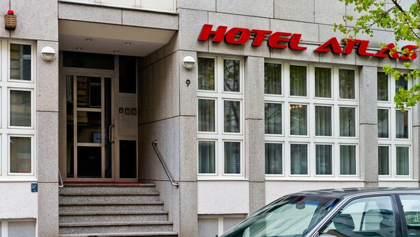 A hotel entrance with a prominent red sign reading "HOTEL ATLANTIS." - Hotel Atlas Berlin (Berlin)