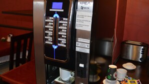A KREA Necta coffee machine with a digital display, dispensing options, and a payment terminal. - Hotel Atlas Berlin (Berlin)