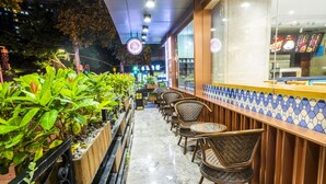 Un espacio al aire libre con sillas de mimbre y una barra con encimera de azulejos.