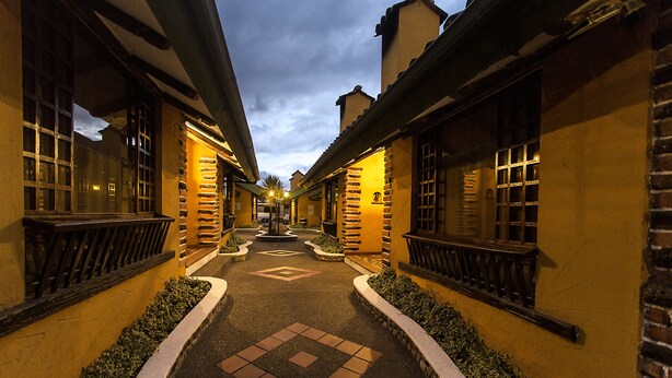 A narrow alleyway between buildings with a paved walkway and decorative tiles. - Hotel Rumipamba de las Rosas (San Miguel de Salcedo)