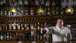 A bar with a bartender pouring a drink into a glass, surrounded by shelves of liquor bottles. - Hotel Rumipamba de las Rosas (San Miguel de Salcedo)