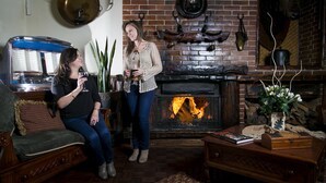 A cozy living room with a brick fireplace, a vintage jukebox, and a comfortable sofa. - Hotel Rumipamba de las Rosas (San Miguel de Salcedo)