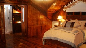A wooden room with a bed, a nightstand, and a lamp. - Hotel Rumipamba de las Rosas (San Miguel de Salcedo)