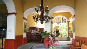 A lobby with a reception desk, a chandelier, and a seating area.