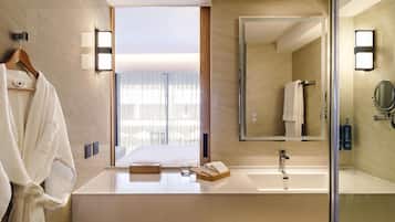A modern bathroom with a large mirror, a sink, and a towel rack.