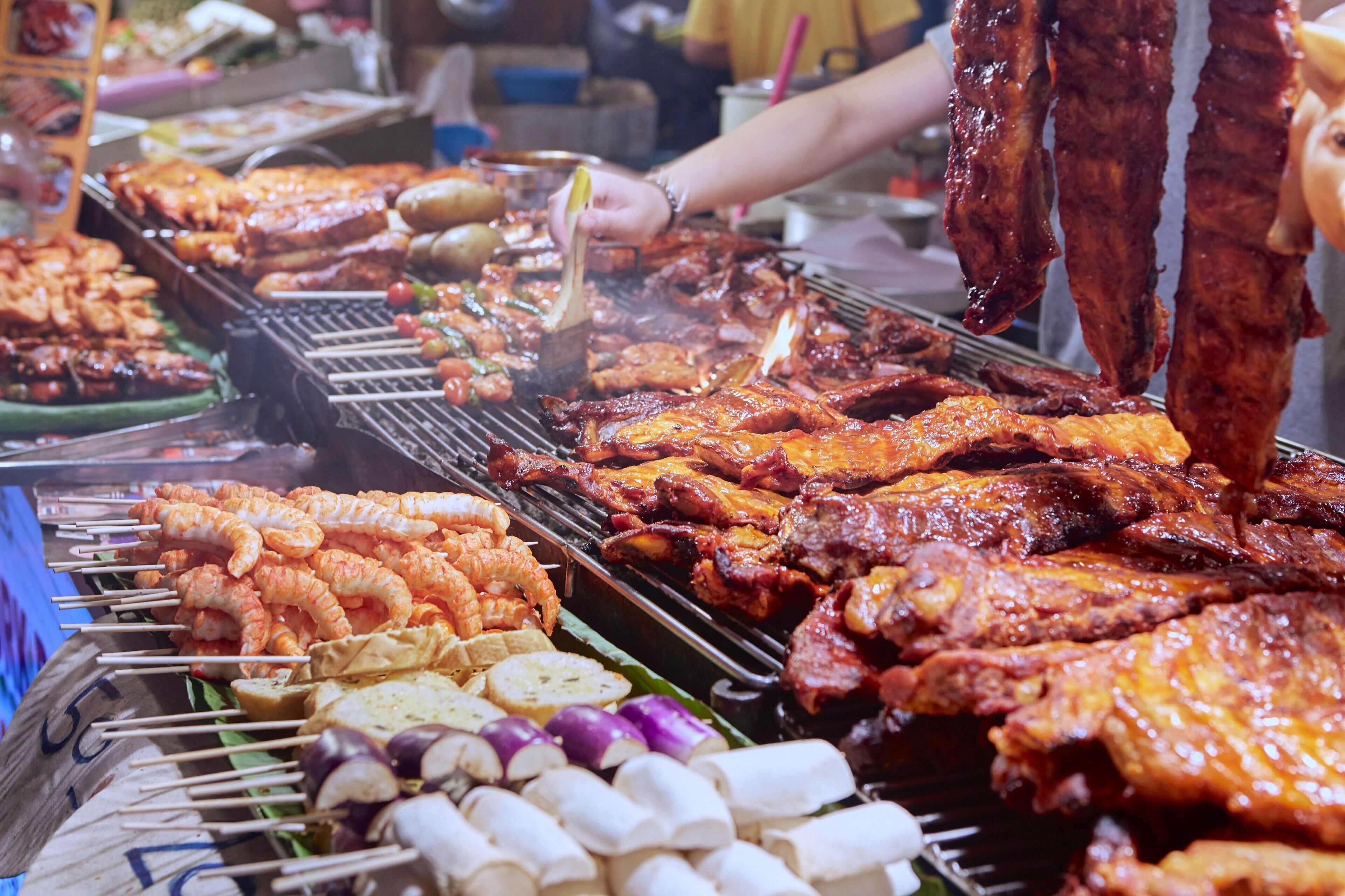 A variety of grilled meats and vegetables on a barbecue grill.