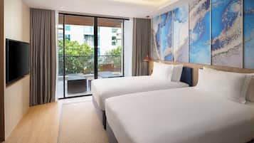 A hotel room with two beds, a flat-screen TV, a large window with a view of the city, and a balcony.