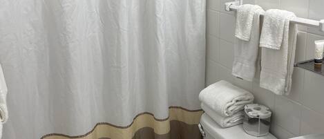 A bathroom with a toilet, sink, and shower curtain.
