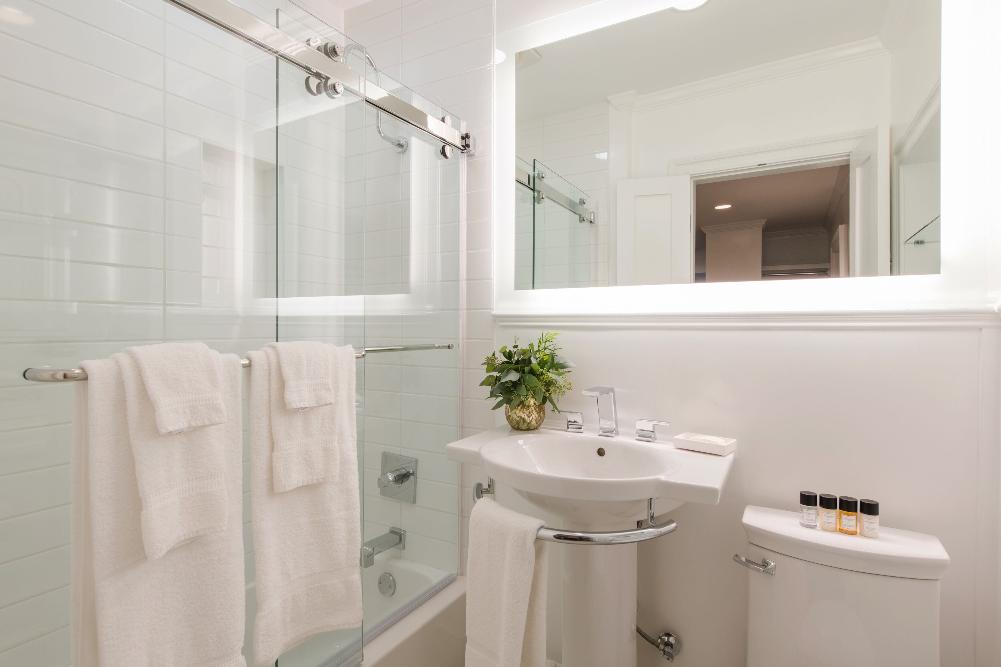 Une salle de bain moderne avec une douche à parois de verre, un lavabo blanc et des toilettes.