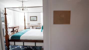 Un dormitorio con cama con dosel, una araña, una placa que dice "Pyramid Suite" y vistas de un comedor.