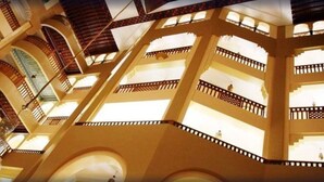 Een atrium met meerdere niveaus, voorzien van balkons en gebogen doorgangen.