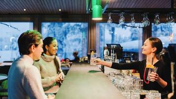 Eine Bar mit einer Theke, Gläsern und einem Barkeeper.