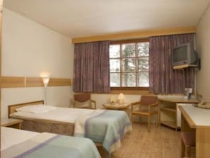 A hotel room with two single beds, a desk, a chair, a television, and a window with curtains. - Hotelli Kieppi (Saariselka)