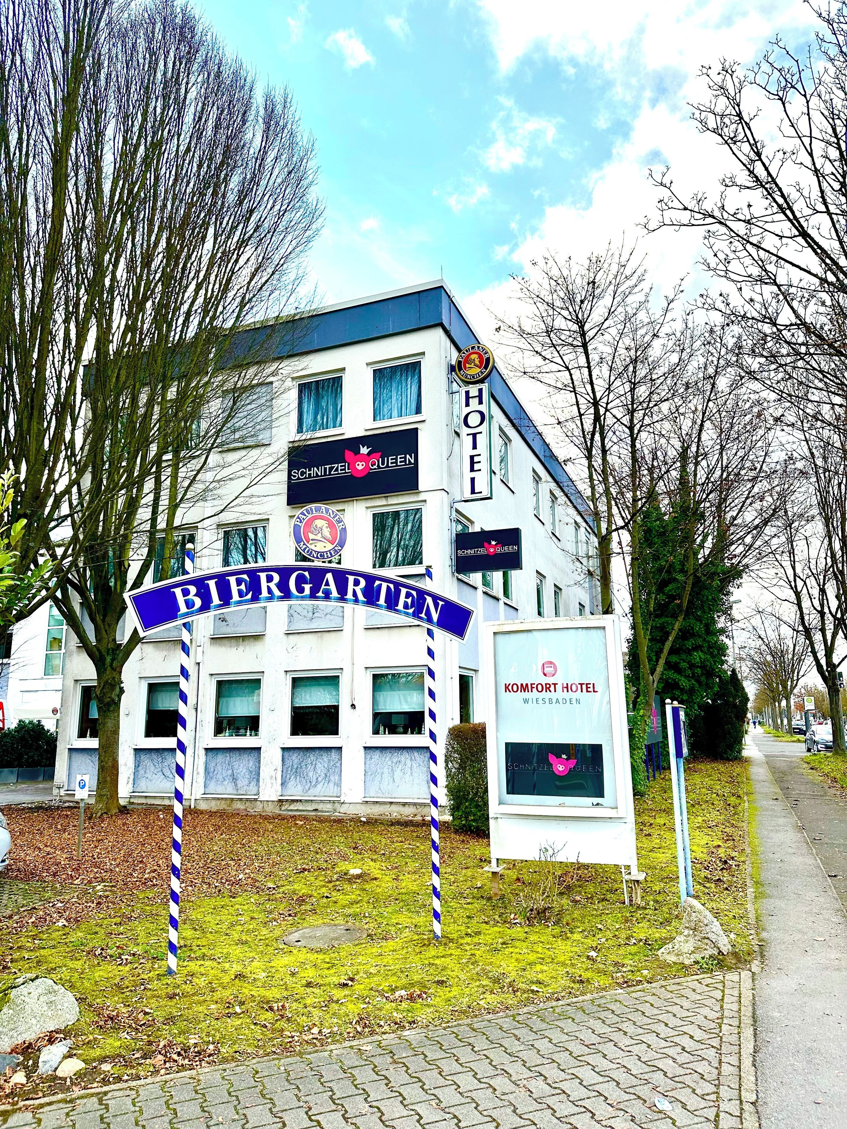A hotel named 'Schnitzel Queen' with a sign indicating 'Biergarten' and 'Komfort Hotel Wiesbaden'.