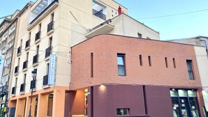 A hotel with a beige facade, a red brick section, and a visible entrance with steps. - Tania-Frankfurt (Bucharest)